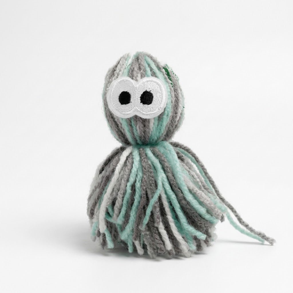 Yarn octopus plush toy with cloud face, mint and gray striped tentacles, dangling tail