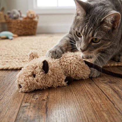 Tan plush crinkle rodent toy with long ears and curled tail, by a tabby cat