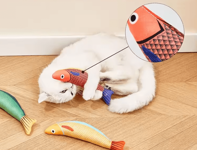 Catnip fish chew toys on floor with cats; plush fish in orange and red colors