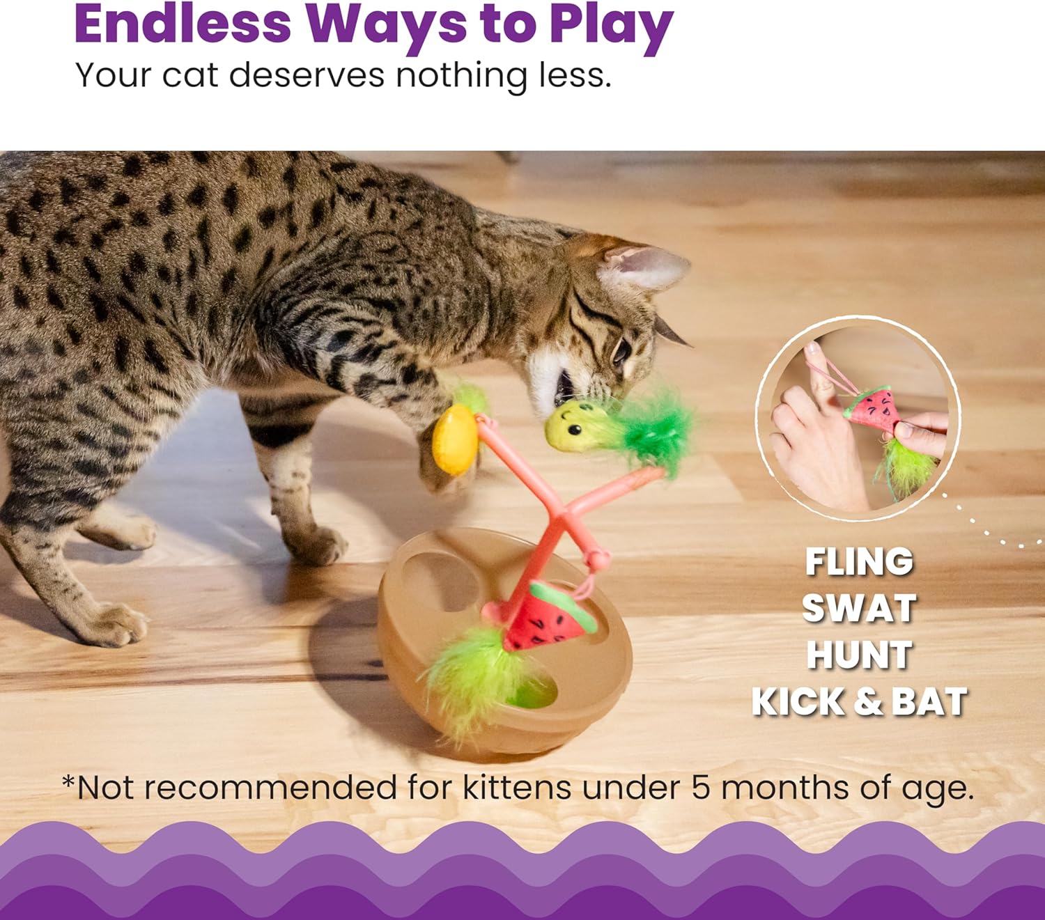 Tabby cat sniffing fruit-bowl wobbling toy with hanging plush fruit and fuzzy green topper
