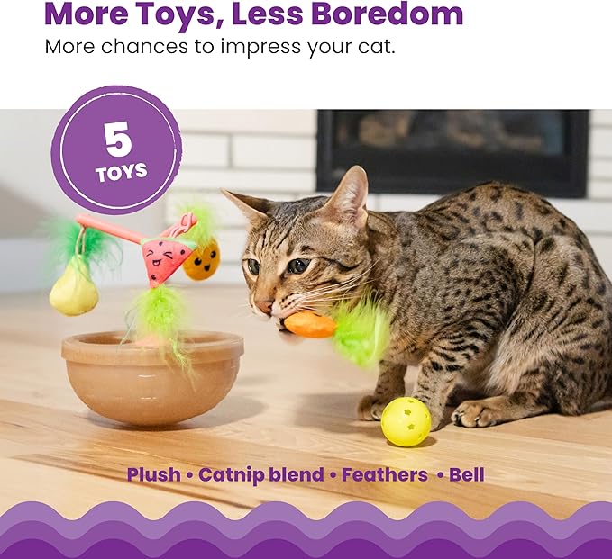 Cat beside fruit-bowl wobbling toy with dangling plush fruit, fuzzy topper, and yellow ball
