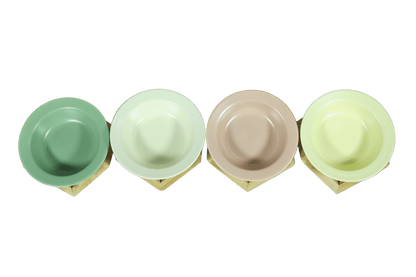 Set of four ceramic cat bowls in green, cream, beige, and light yellow