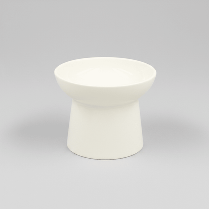 White tilted ceramic cat bowl, empty with a smooth rounded rim