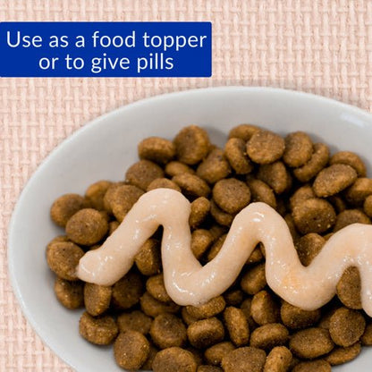 Cat treat pellets topped with creamy chicken paste in white bowl