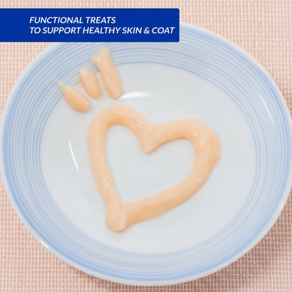 Creamy lickable cat treat paste in blue-rim bowl, pale peach