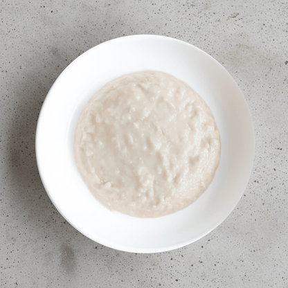 White ceramic bowl filled with pale kitten mousse cat food