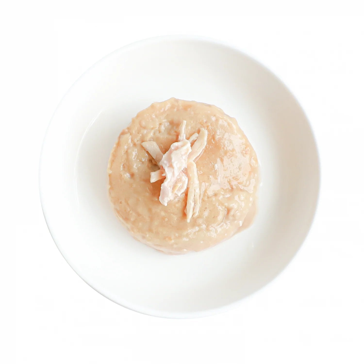 Cat mousse in a bowl, light beige with shredded chicken pieces visible