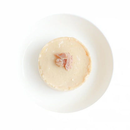 Cat mousse in a bowl, pale cream texture with small tuna pieces visible