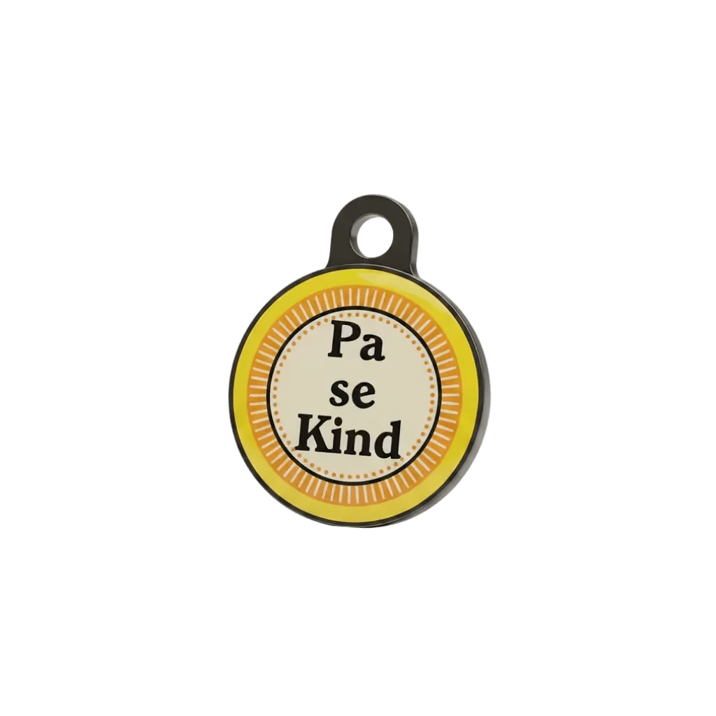 Round metal cat ID tag with 'Pa se Kind' text on yellow striped background.
