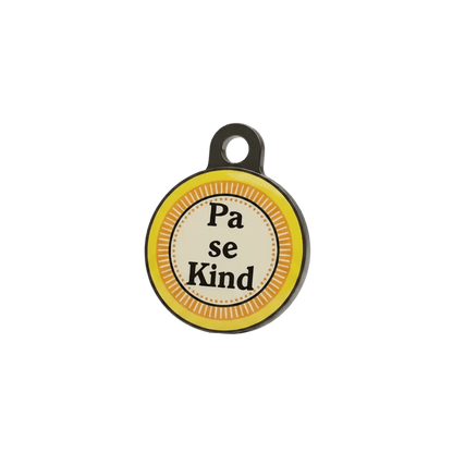 Round metal cat ID tag with 'Pa se Kind' text on yellow striped background.