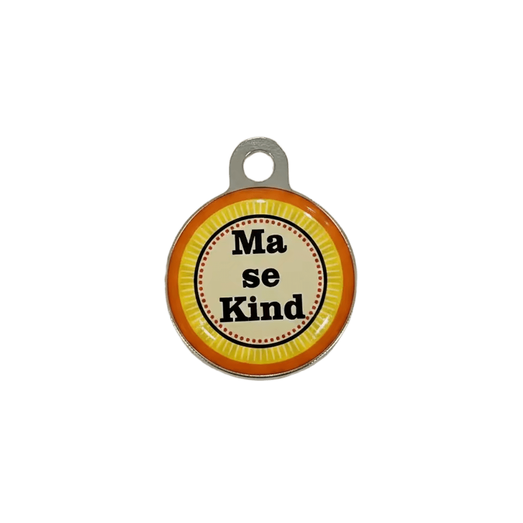 Round metal cat ID tag with 'Ma se Kind' text on orange-yellow striped background.