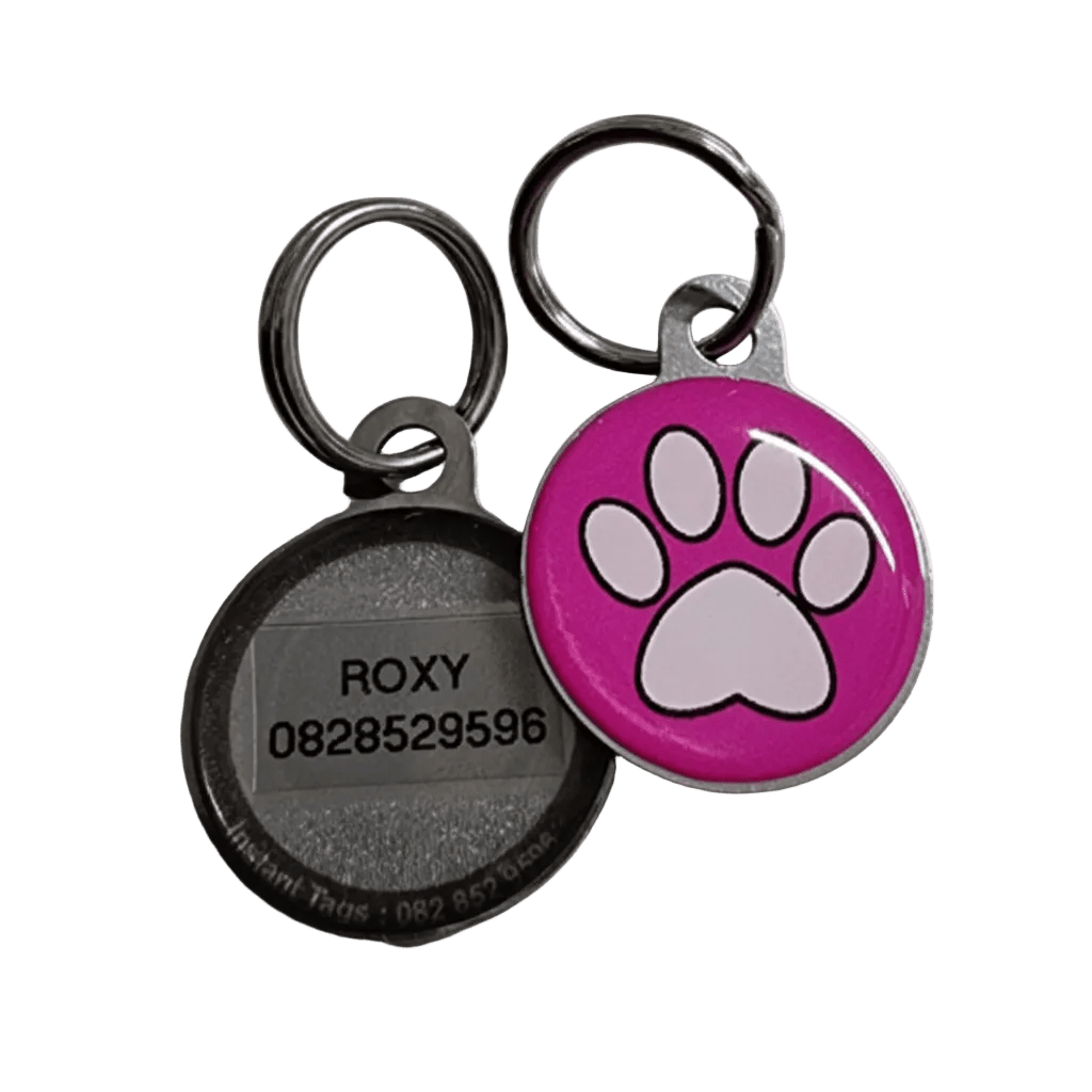 Cat ID tag pair with pink paw print and engraved name/number on dark back.