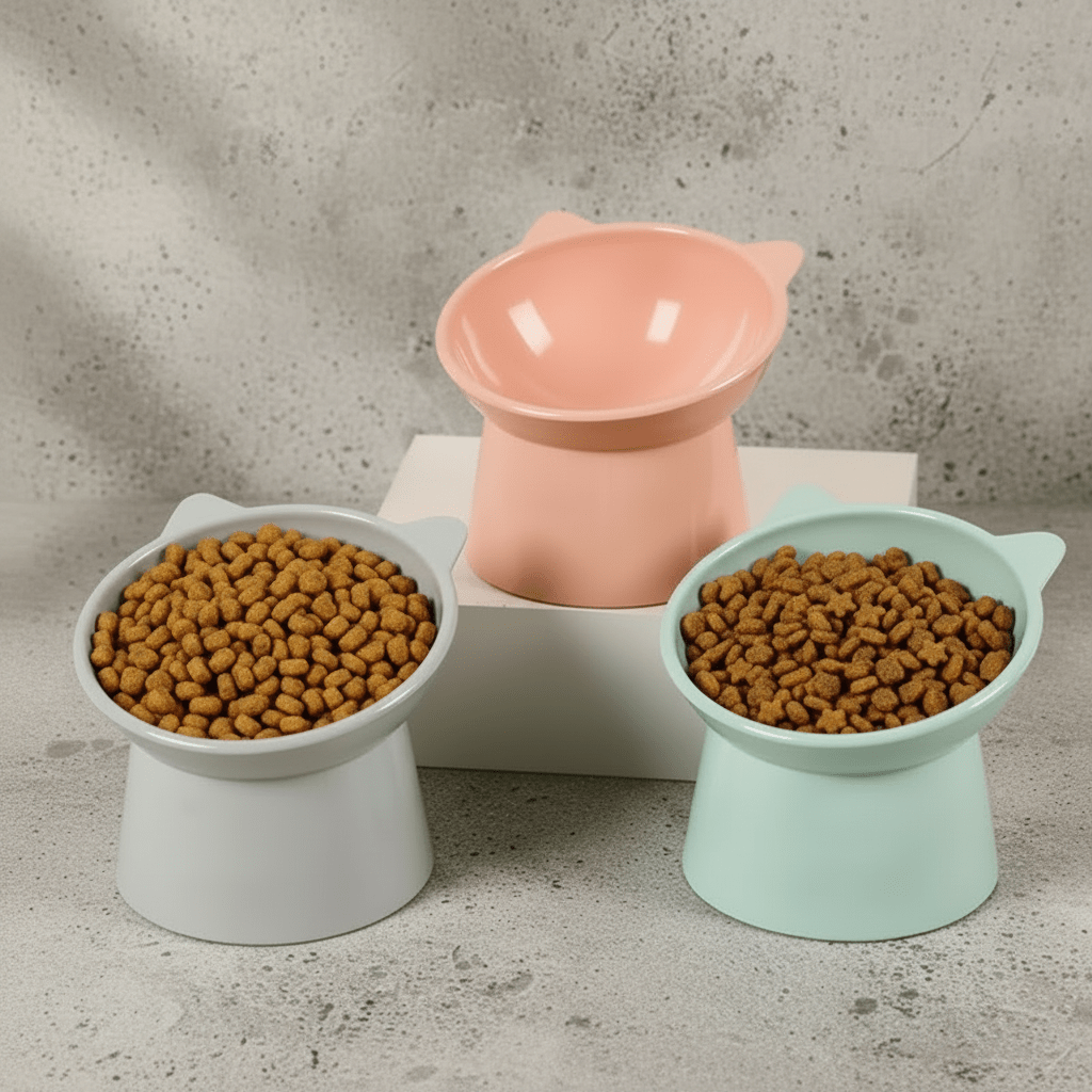 Raised cat feeding bowls in peach, mint, and gray with kibble inside
