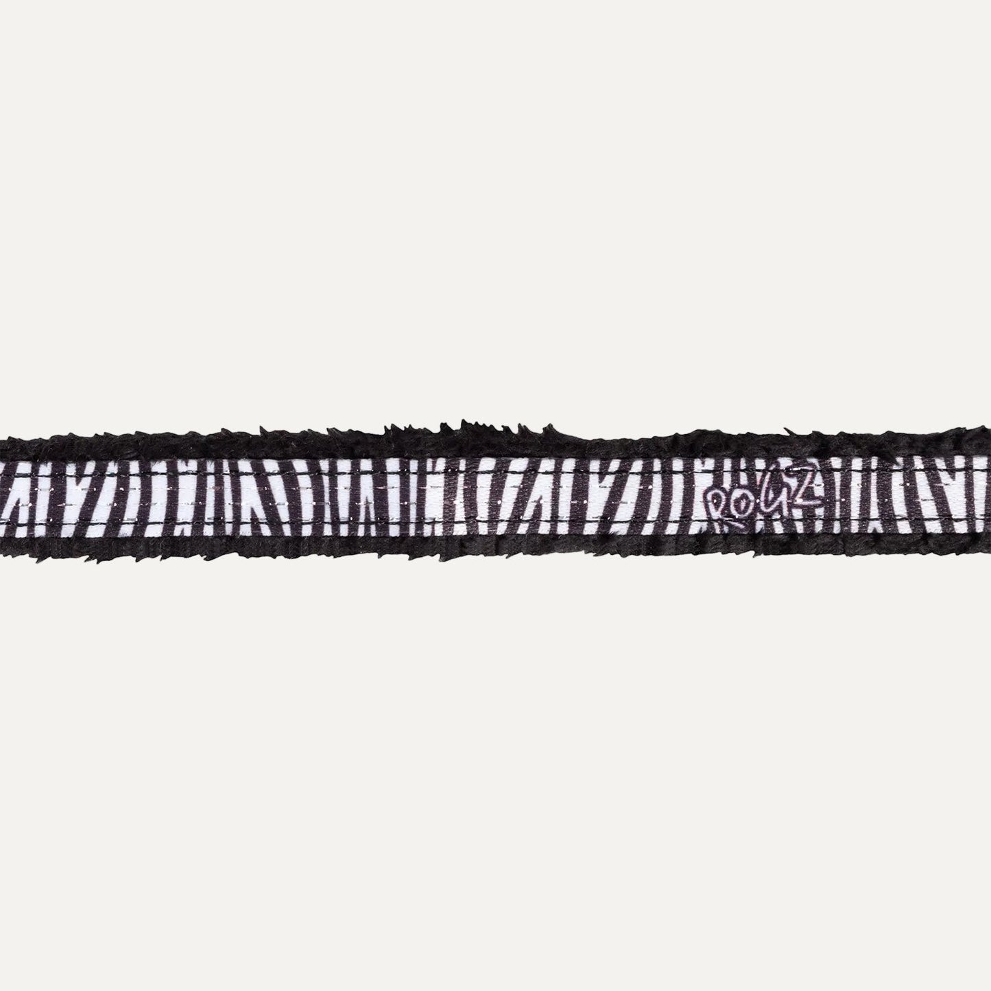 Close-up of black zebra patterned padded edge on cat safety collar.