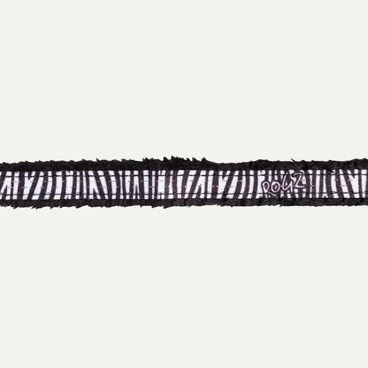 Close-up of black zebra patterned padded edge on cat safety collar.