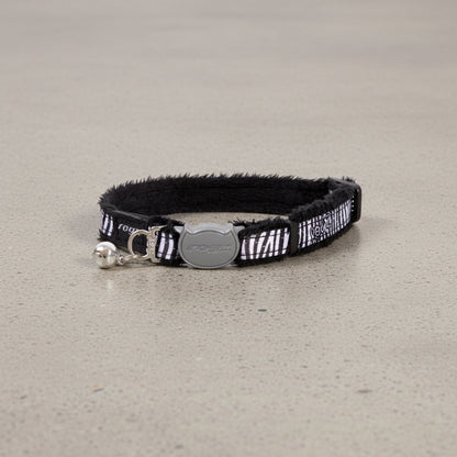 Black cat safety collar with zebra pattern, silver buckle, and small bell attachment.