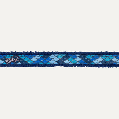 Close-up of blue padded edge on cat safety collar with scale pattern fabric.