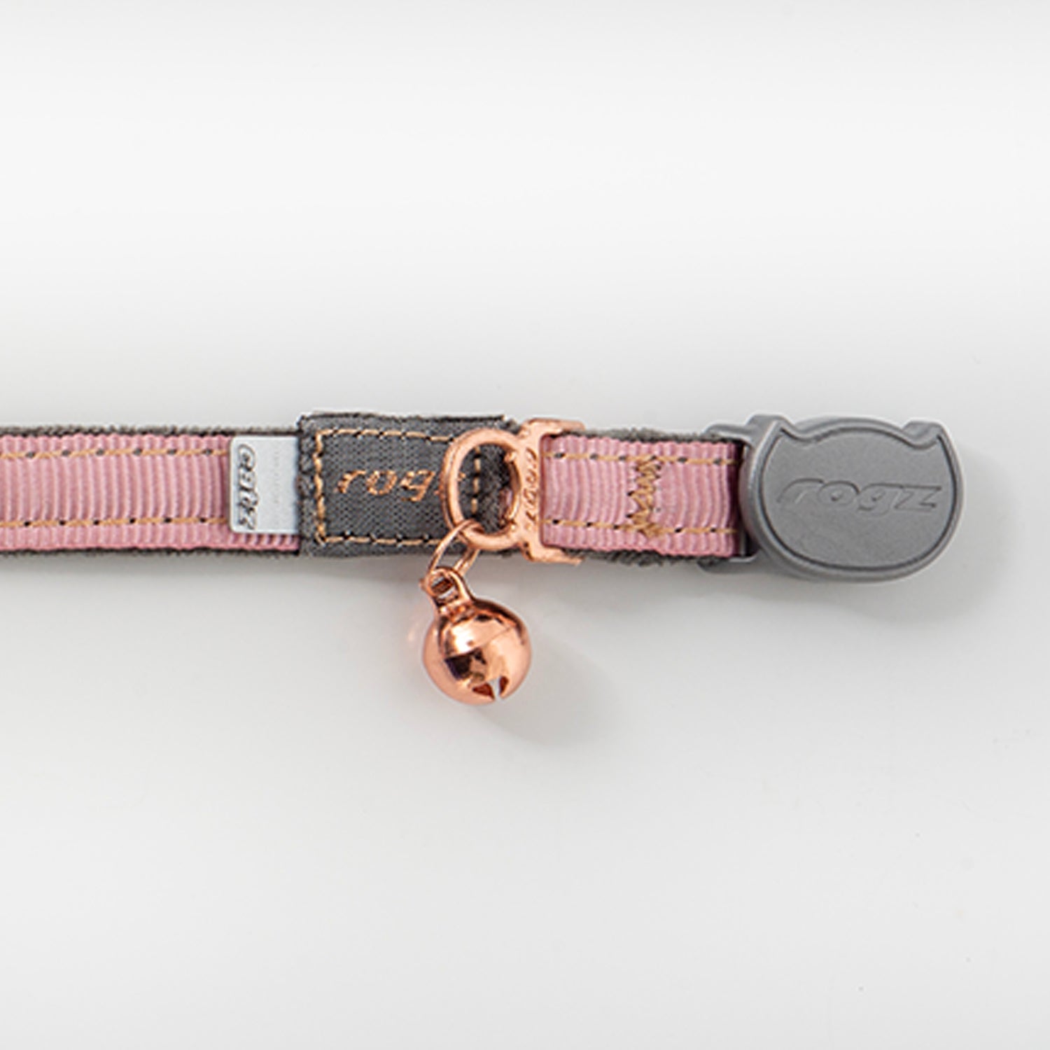 Pink webbing cat collar close-up with rose-gold bell and rogz clasp