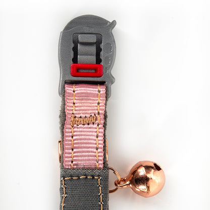 Pink cat collar detail with red release tab, rose-gold bell, rogz clasp